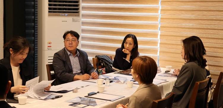 The image depicts a meeting room setting with a large table, documents, and people engaged in a discussion, with Samsung's logo visible on one of the documents.

AI 생성 콘텐츠는 정확하지 않을 수 있습니다.
